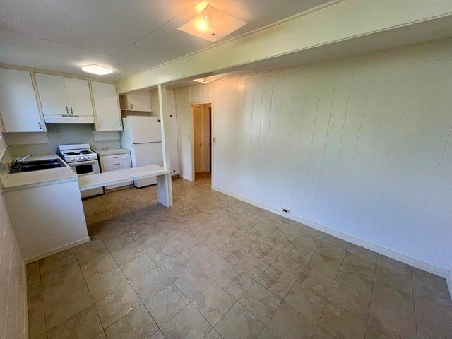 A kitchen with white cabinets and a tiled floor.